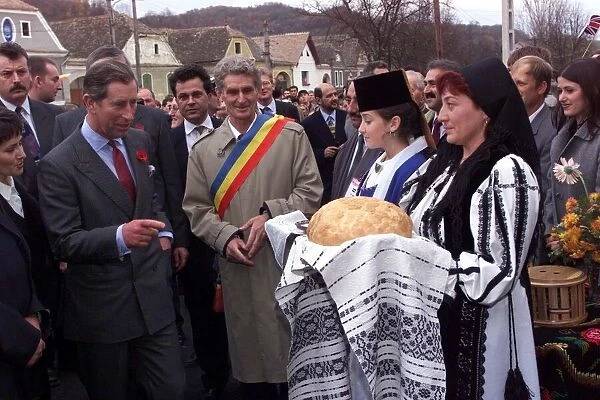 Prince Charles tastes bread and salt prepared by local women wearing traditional costume
