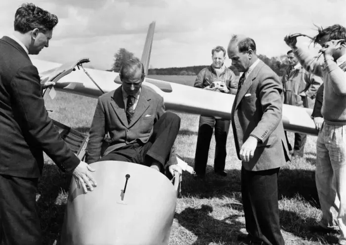 Framed Print : Prince Philip climbs into the cockpit while Peter Scott Looks on (right) Framed Print : Prince Philip climbs into the cockpit while Peter Scott Looks on (right)
