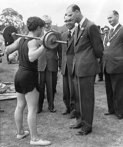 Prince Philip, Duke of Edinburgh, shows interest in a demonstation of weight-lifting