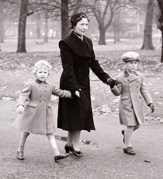 Princess Anne and Prince Charles walk through Green Park with their Governess on their