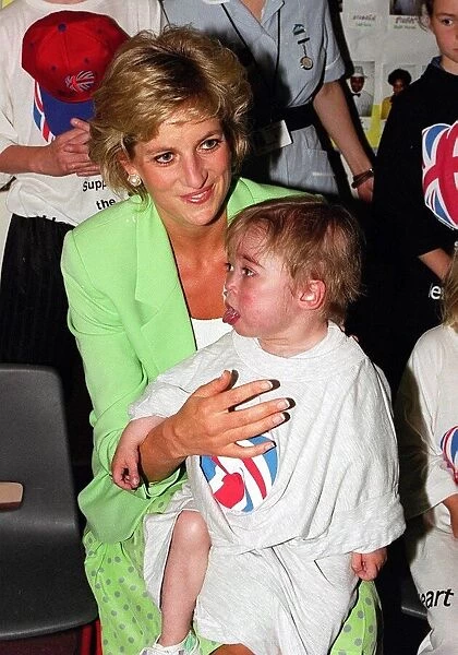 Princess Diana with Darius Wyke sitting on her knee on a visit to a Children