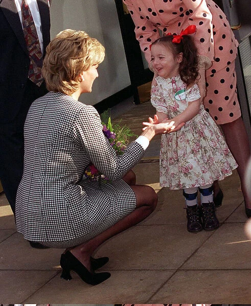 Princess Diana shaking the hand of a youngster who attends the Institute for Conductive