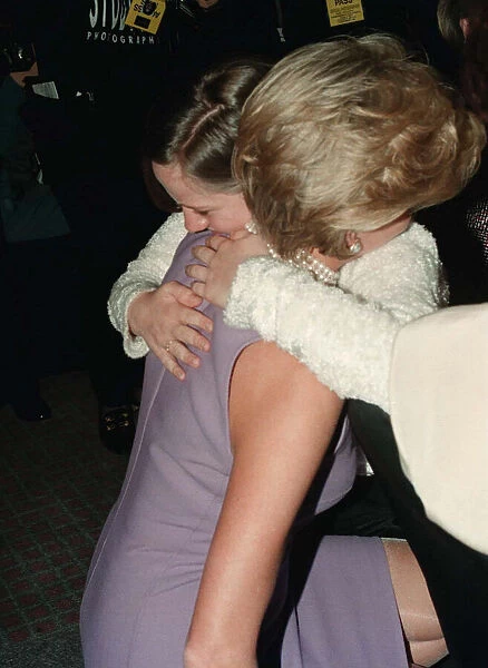 Princess Diana, wearing a purple dress, hugs Emma Jones at a Commonwealth Day luncheon in
