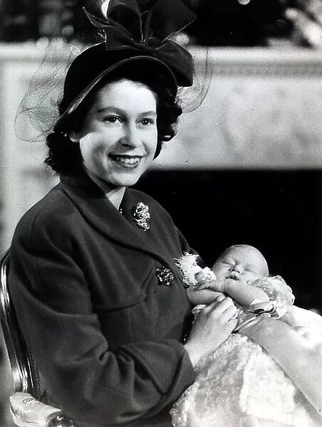 Princess Elizabeth holds her baby son Prince Charles in the drawing room at Buckingham