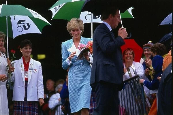 Princesss Diana, Princess of Wales, sheltering from the rain during a walkabout in