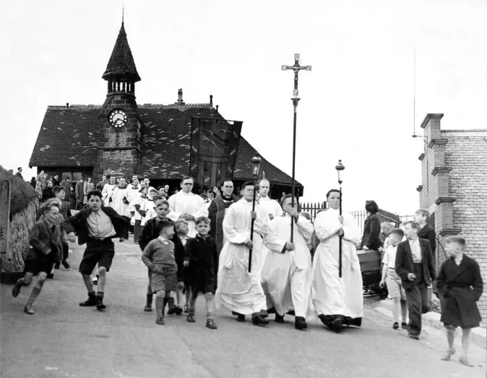 Framed Print : The procession make their way past the Clock Tower down to the beach