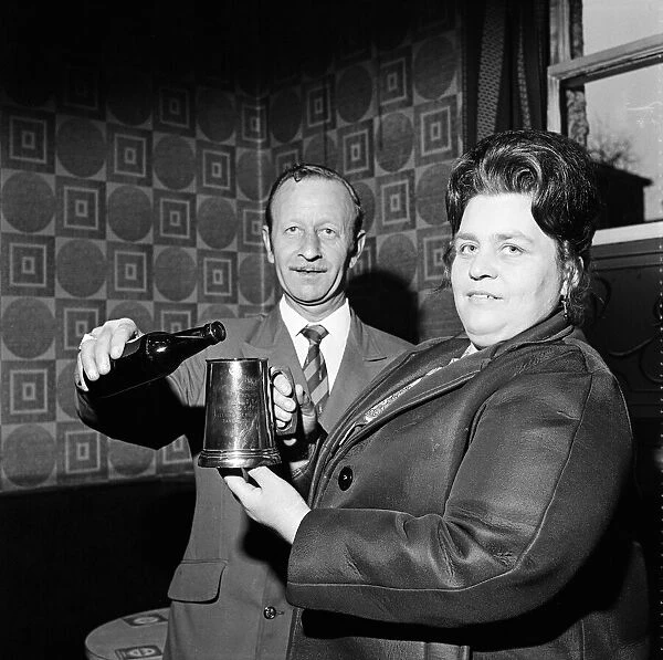 Pub landlord presents a tankard to a widow, Teesside. 1974