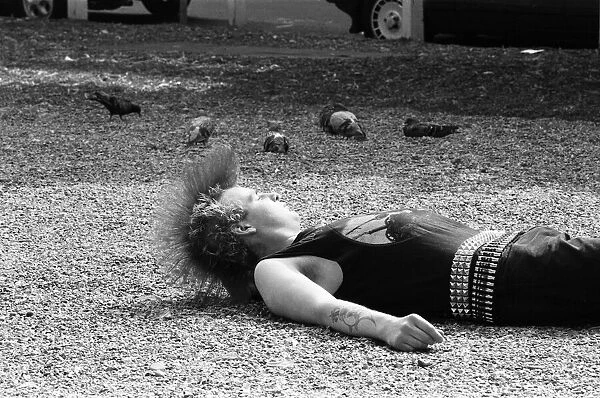 A punk relaxing in midday sun in Chelseas Kings Road. 20th August 1984