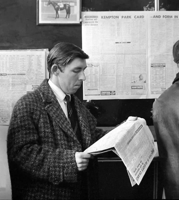 Framed Print : A punter checks the racing guide in a newspaper before making his bet at a race Framed Print : A punter checks the racing guide in a newspaper before making his bet at a race