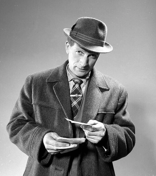 A punter holding his betting slips before placing his bet March 1963