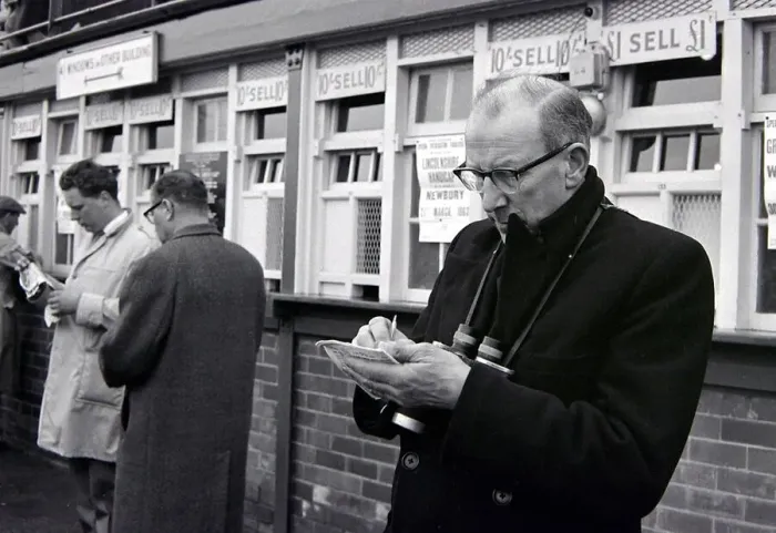 Framed Print : A punter making notes before placing his bet during a day out at the races March Framed Print : A punter making notes before placing his bet during a day out at the races March