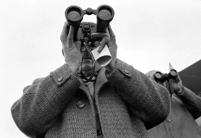 Framed Print : A punter watching the race through binoculars after making his bet march 1963