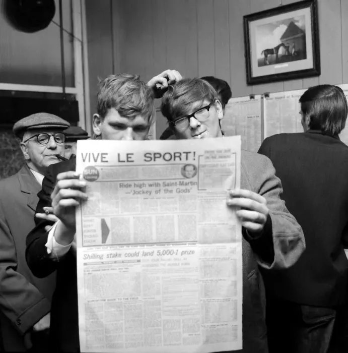 Framed Print : Punters studying the form guide in a French newspaper before placing their bets Framed Print : Punters studying the form guide in a French newspaper before placing their bets