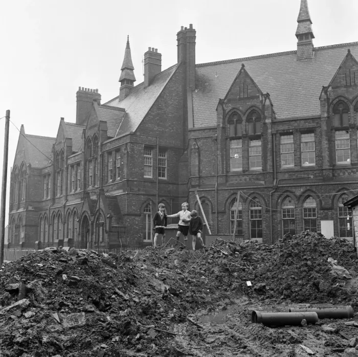 Framed Print : Pupils of Ross Place School, Ardwick, Manchester, jump across a sea of mud to enter Framed Print : Pupils of Ross Place School, Ardwick, Manchester, jump across a sea of mud to enter