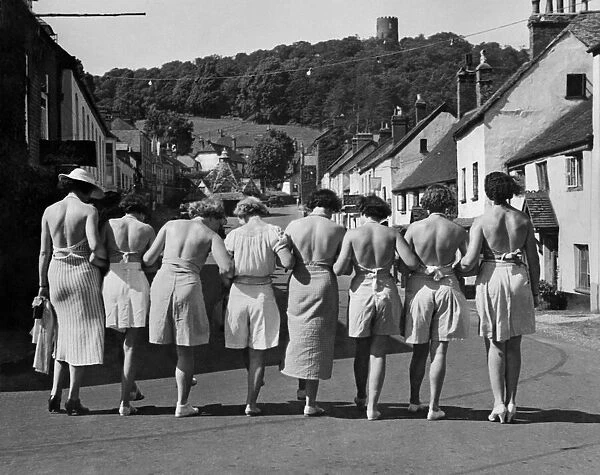 Putting their backs into their holiday. A group pf women walking down the street wearing