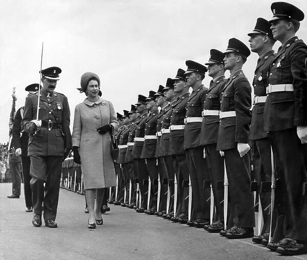 The Queen, accompanied by Major M Pim, inspects the Guard of Honour of the 1st Battalion
