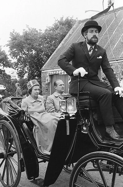 Queen Elizabeth and the Duke sitting in a horse-drawn carriage during a vist to