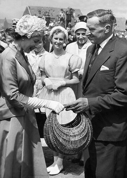 Queen Elizabeth II is presented with a willow basket by Mr J Tough during her visit to