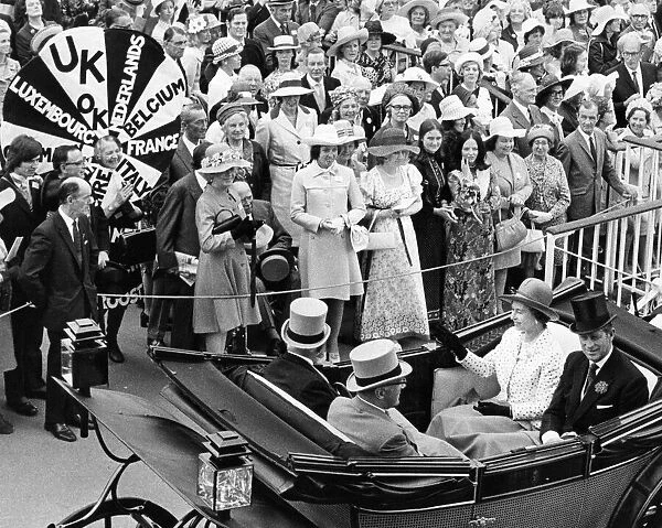 Queen Elizabeth II and Prince Philip drive down the course at Royal Ascot waving at