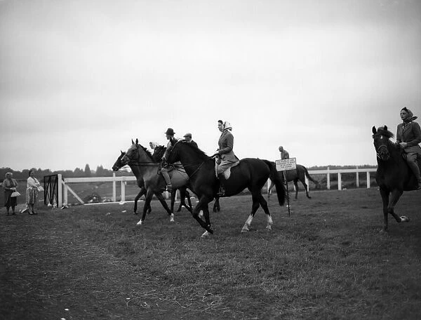 Queen Elizabeth II riding a horse at Ascot racecourse. She was racing against other
