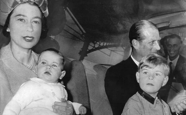 Queen Elizabeth II sitting in the back of car, holding a young Prince Edward on her lap