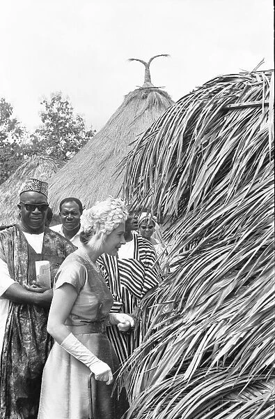 Queen Elizabeth looks in on one of the village huts during a visit to Hangha in Kenema