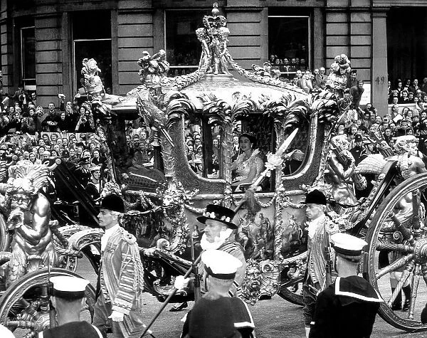 Queen Elizabeth smiles from the coach as the Coronation procession passes King Charles