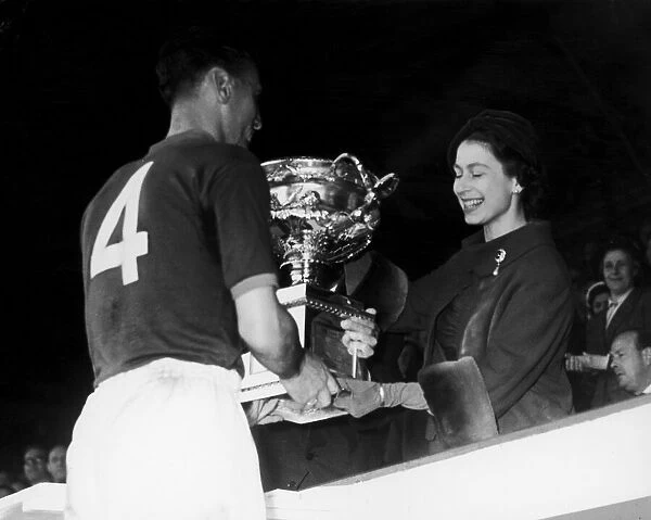 The Queen is seen here presenting the cup to Craftsman R. Nelson, Captain of the R. E. M