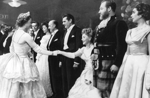 The Queen shaking hands with Glynis Johns watched by Kack Hawkins