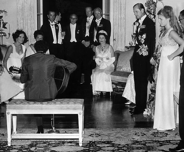 The queen watching Baden Powell on the guitar, during a visit to Brazil