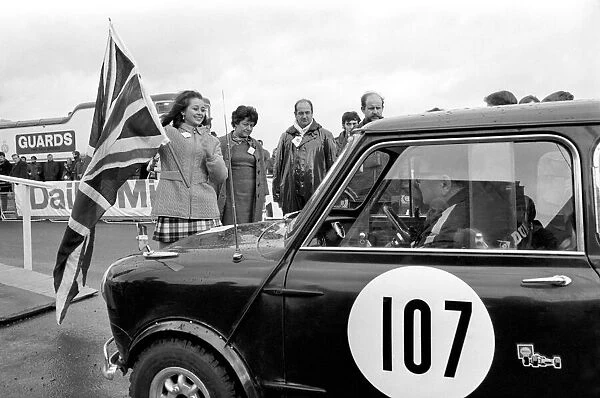 R. A. C. Rally Start: Miss U. K. Sheena Drummond pictured with Union Jack waves off Car No