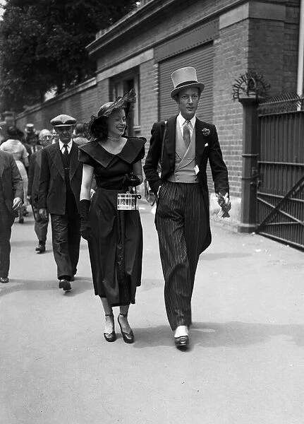 Two racegoers walk down the street to the races. Ascot, June 1949