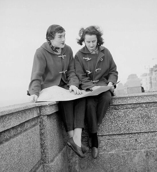 Racing drivers Pat Moss and Ann Wisdom aged 21, study their map on the promenade in