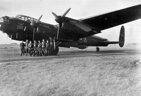 An RAF crew pose for a group photograph beside the veteran Lancaster bomber '