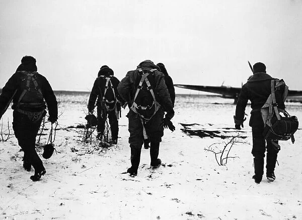 RAF pilots trudge through the snow to their aircraft on a French aerodrome for a flight