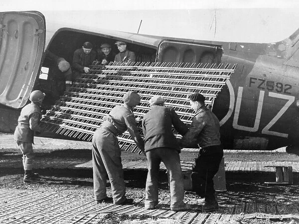 The RAF unloading metal runway strips from a Dakota transport plane in Belgium