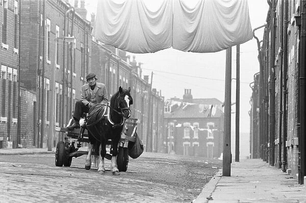 A rag and bone man at the reins of his horse and cart seen here travelling the streets of