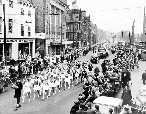 The rag headed by the Majorettes, makes its way through surging crowds in