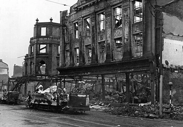 Raid damage at Sheffield. Burned out tramcars and shops, Fitzalan Square