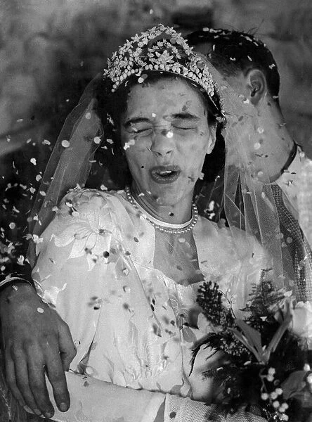 Its raining confetti. The happy bride under the barrge of confetti is 19years old