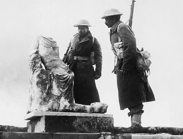 Two Rajput riflemen looking at a piece of archaic statuary in the ruins of the ancient