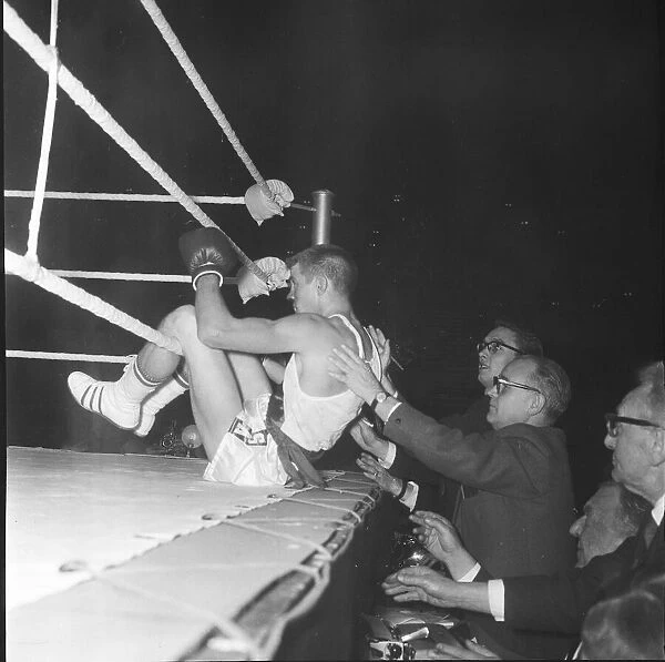 Ralph Ungricht gets a helping hand from the ringside reporters after being knocked out of