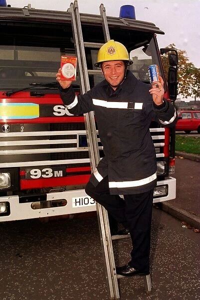 Rangers football player Ally McCoist as a fireman with a smoke alarm in one hand