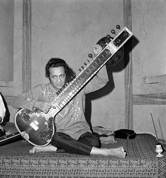 Ravi Shankar bare footed, plays his sitar at the Hyde Park Hotel
