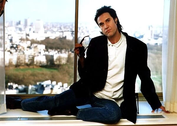 Ray Davies The Kinks pop group singer sitting on office window ledge March 1990