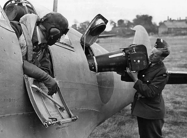 Reconnaissance equipment is fitted to the fuselage of a Spitfire by airmen of a Royal Air