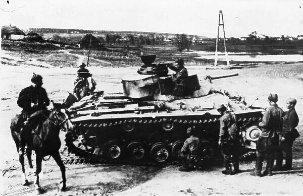 Red Army guardsmen inspecting an abandoned German tank. It is in a village where