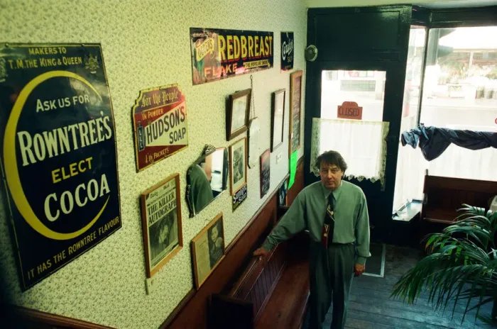 Framed Print : Redcar barber Mike Forbes with some of his collection of memorabilia in his shop Framed Print : Redcar barber Mike Forbes with some of his collection of memorabilia in his shop