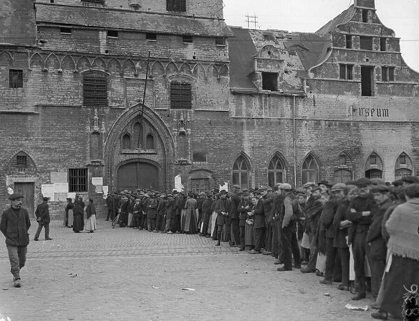 Refugees from the fighting seen here queuing outside the City Hall in Malines waiting for