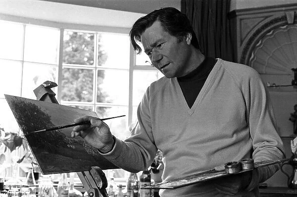 Reg Varney, actor and painter, touches up his latest work, at home in Enfield